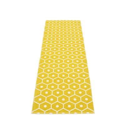 Pappelina Honey Kunststoffteppich 70x225 cm mit gelbem Wabenmuster und weißen Akzenten. Robuster Teppich für Innenräume.